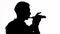 Silhouette. Isolated. The guy plays a beautiful melody on the flute. Profile of the musician. Copy space.