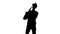 Silhouette jazzman performs solo on saxophone. White background in studio