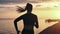 Silhouette of jogger female training at seashore with sea and sky. Shot with RED camera in 4K