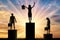 Silhouette of a jubilant woman on the podium of a winner and a silhouette of a sad man and woman near