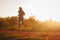 Silhouette of a kenyan runner running along a red dirt road near the city of Iten in Kenya. Athletic sports photo for long track