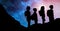 Silhouette kids with backpacks against sky at night