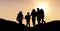 Silhouette kids with backpacks against sky during sunset