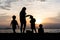 The silhouette of kids and mother at the beach in evening.