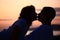 Silhouette kissing man and woman on beach