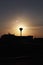 Silhouette of a lantern at dawn over the city. The sun shines from a lantern. Clear sky, calm and silence of the morning