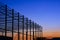 Silhouette large industrial building structure in construction area against colorful twilight sky background