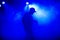 Silhouette of lead in cap of rocker on stage in smoke in nightclub at concert