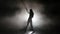 Silhouette leggy girl dancing in a smoky studio rhythmic dance