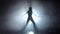 Silhouette leggy girl dancing in smoky studio. Slow motion