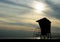 Silhouette of lifeguard tower under smoky sky