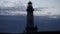 Silhouette of lighthouse against cloudy sky at dusk