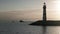 Silhouette of lighthouse with fishing boat