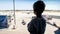 Silhouette of little boy looking on landing airplanes at airport through big window