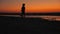 Silhouette of a little boy walking across a dried up salt lake after sunset