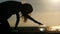 Silhouette little girl playing with her pet gold fish in aquarium seashore at sunset