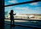 a silhouette little girl standing by the window at the airport.