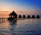 Silhouette of lodges in the sea at sunset. Maldives