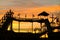 Silhouette of log flume ride retro style against golden sunset sky