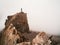 Silhouette of a lone tourist over a cliff. Sharp rocks. Mystical