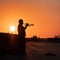 Silhouette of a lone Trumpeter playing his Trumpet at Sunset in a Public Area