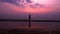 Silhouette. Lonely Asian young man walking peacefully along a deserted beach at sunset. Seascape