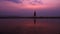 Silhouette. Lonely Asian young man walking peacefully along a deserted beach at sunset. Seascape