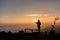 Silhouette lonely girl standing on top of mountain with sunrise.Tourist traveler at sunrise