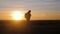 Silhouette lonely man with backpack in the mountains walking at the setting sun and the sunset. The concept of tourism