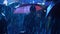 Silhouette lonely woman under an umbrella among people in rain at concert in flashing lights