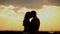 Silhouette in love on sunset. Passionate kiss.