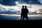 Silhouette lovely couple in a field at sunset with a dramatic sky