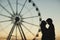 Silhouette of a loving couple in the evening. Behind them are the wheel of inspection