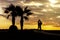 Silhouette of loving couple, palm trees and antique amphora.