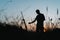 Silhouette of a male artist painting a sunset landscape outdoors in a natural landscape