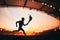 Silhouette of Male Athlete Leading the Relay, with a Modern Track and Field Stadium as the Striking Backdrop. A Captivating Photo