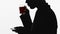 Silhouette of male boss drinking tasty black tea during break, water balance