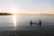 Silhouette of male and female in yoga pose on sup surf swimming at the ocean. Concept lifestyle, sport, love