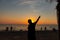 Silhouette of a male holding hands on the beach at sunset