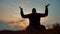 Silhouette of a male monk engaged in meditation at sunset sunlight. Buddhist prays at sunset healthy lifestyle way of