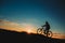 Silhouette of a male mountainbiker at sunset in the mountains