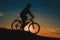 Silhouette of a male mountainbiker at sunset in the mountains