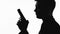 Silhouette of male serial killer holding gun, preparing to shoot, crime and law