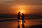 silhouette of a man asking a woman to marry him on a beach at sunset