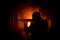 Silhouette of man with assault rifle ready to attack on dark toned foggy background or dangerous bandit in black wearing balaclava