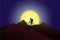 Silhouette of a man with a back pack riding the bicycle in the mountains against huge moon