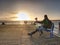 Silhouette of man with backpack on the pier on the calm sea