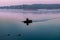 Silhouette of man in a boat in the early morning. pink dawn with ducks