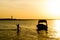 Silhouette of man carrying the anchor of boat out to sea