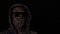 Silhouette man in dark glasses and hood from binary code on black background. Concept internet fraud, web attack